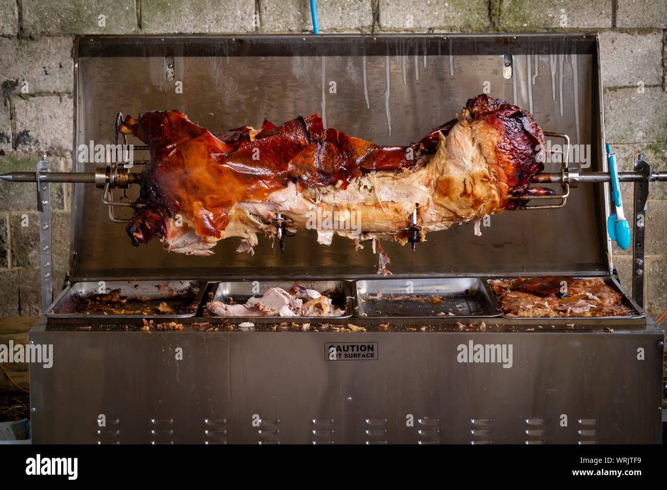 Essendo di maiale arrosto allo spiedo in un involucro metallico Foto Stock