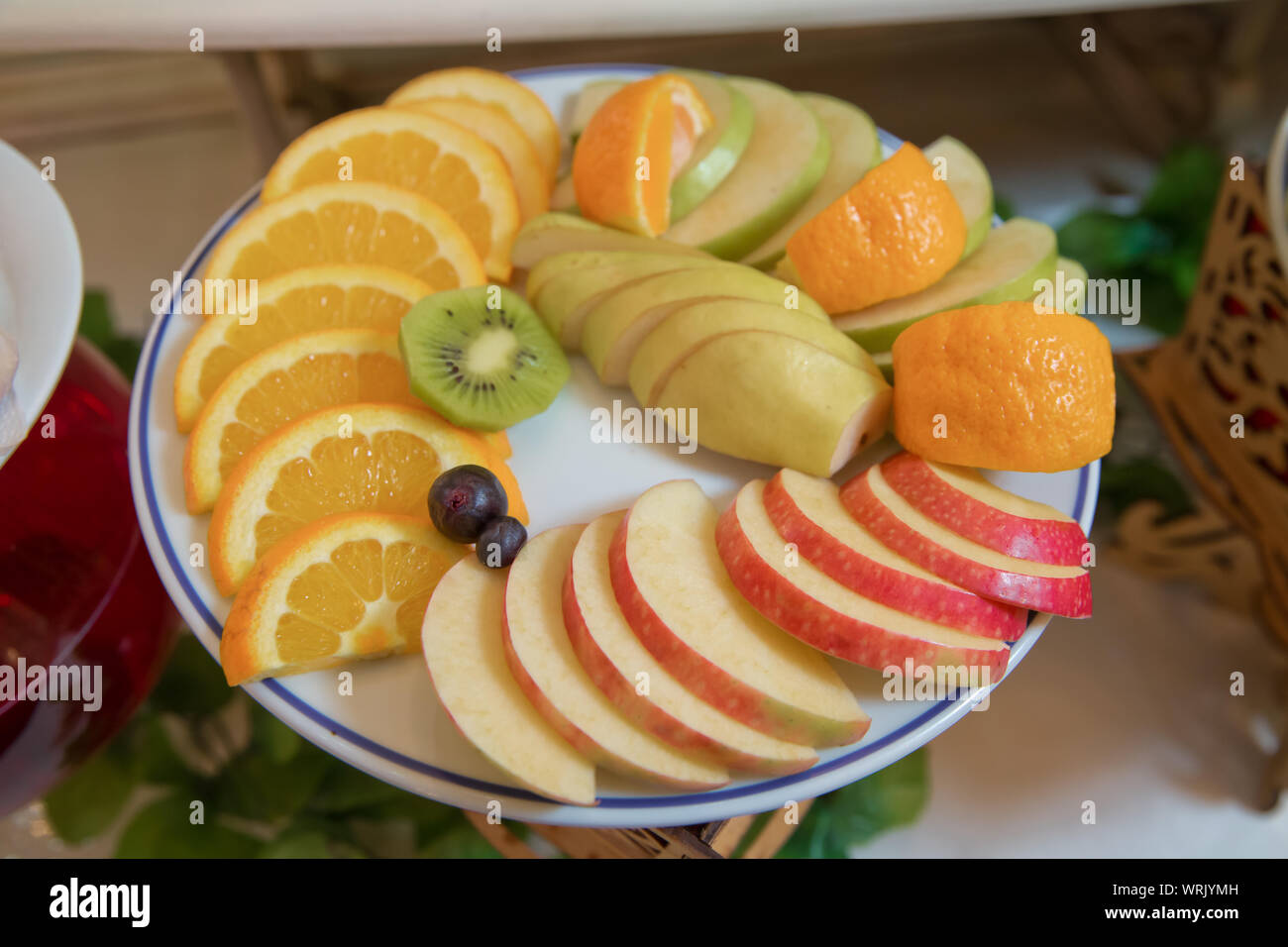 Apple rosso, arancio, pere, kiwi, uva. frutta a fette sono all'interno della piastra. Foto Stock