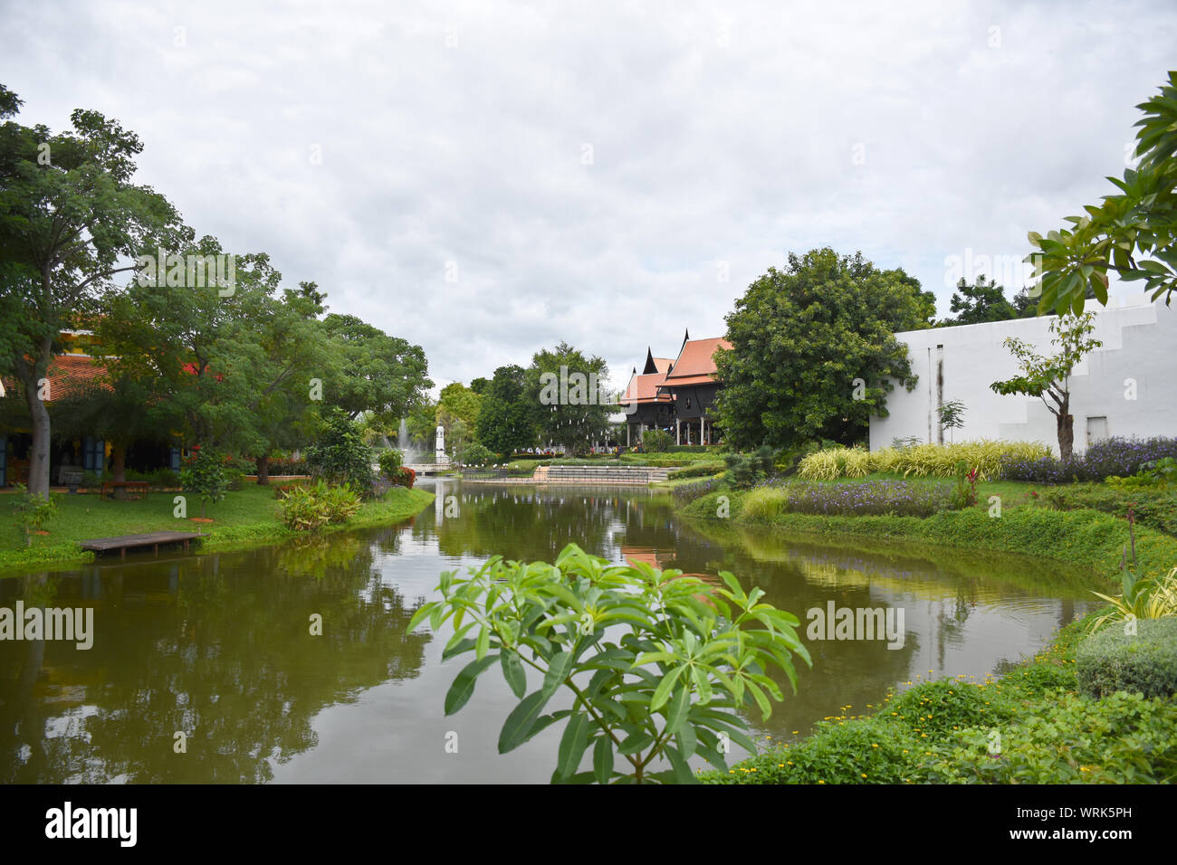 Kanchanaburi, Thailandia, 09.09.2019: bellissimo giardino, lago, tailandese tradizionale Siamese, vestiti, edifici di 'Mallika città R.E. 124' un patrimonio, retro- Foto Stock