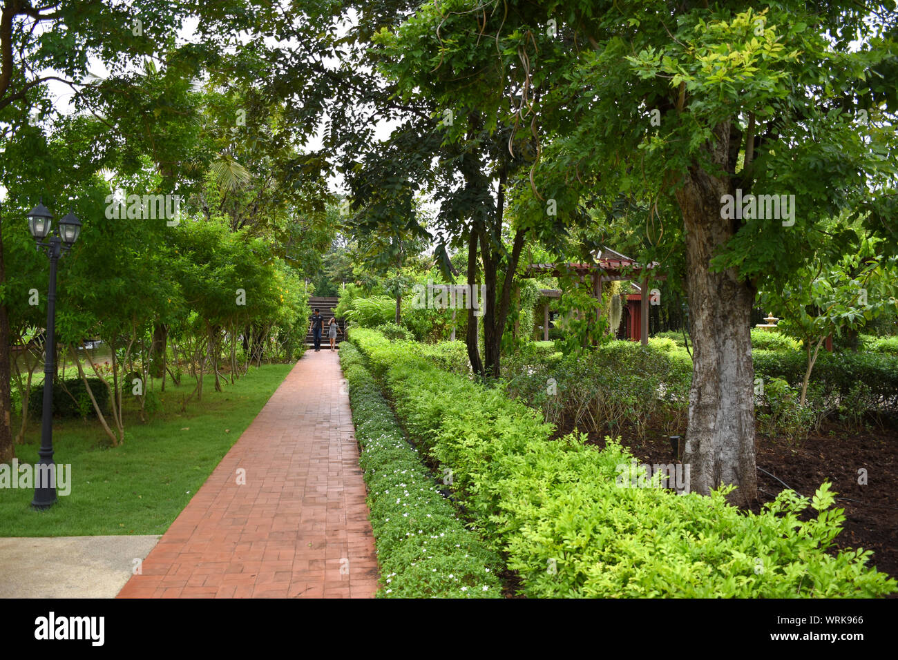 Kanchanaburi, Thailandia, 09.09.2019: bellissimo giardino, lago, tailandese tradizionale Siamese, vestiti, edifici di 'Mallika città R.E. 124' un patrimonio, retro- Foto Stock