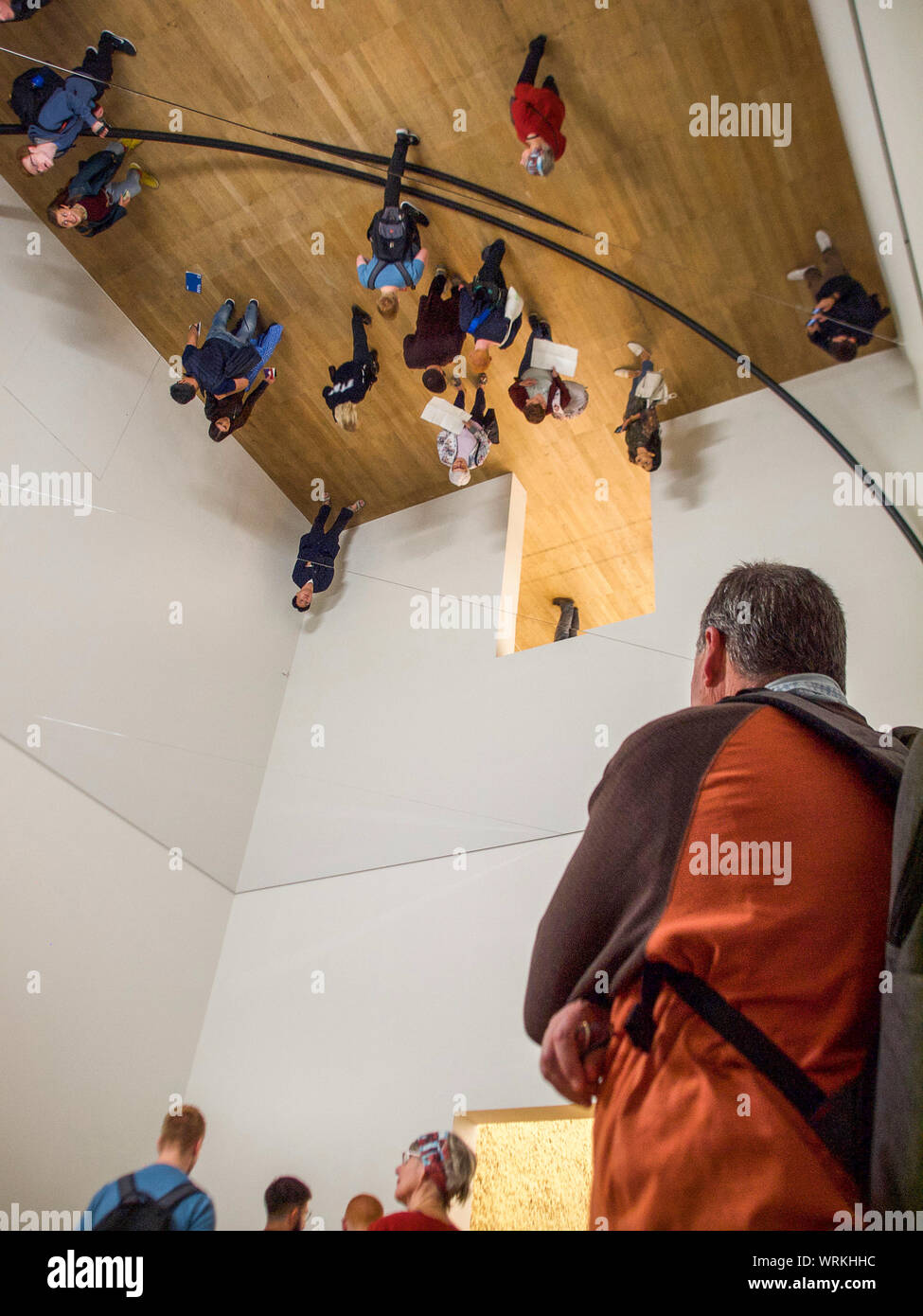 Nero gigante il tubo in acciaio viene visualizzato a cerchio elevato overhead dovuto al soffitto a specchio in Olafur Eliasson retrospettiva Foto Stock