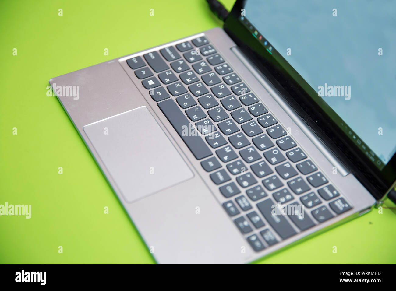 Laptop moderno computer su sfondo verde. Il concetto di lavoro in ufficio.metallo tastiera portatile di piccole profondità di campo . Il lavoro di ufficio con i notebook Foto Stock