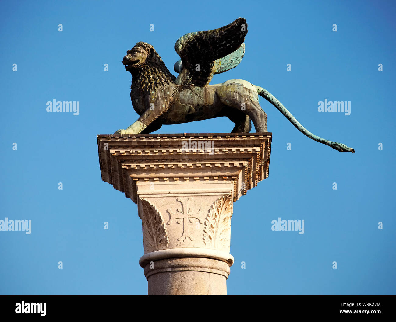 Statua del leone alato su colonna contro il cielo blu e chiaro a San Marco Foto Stock