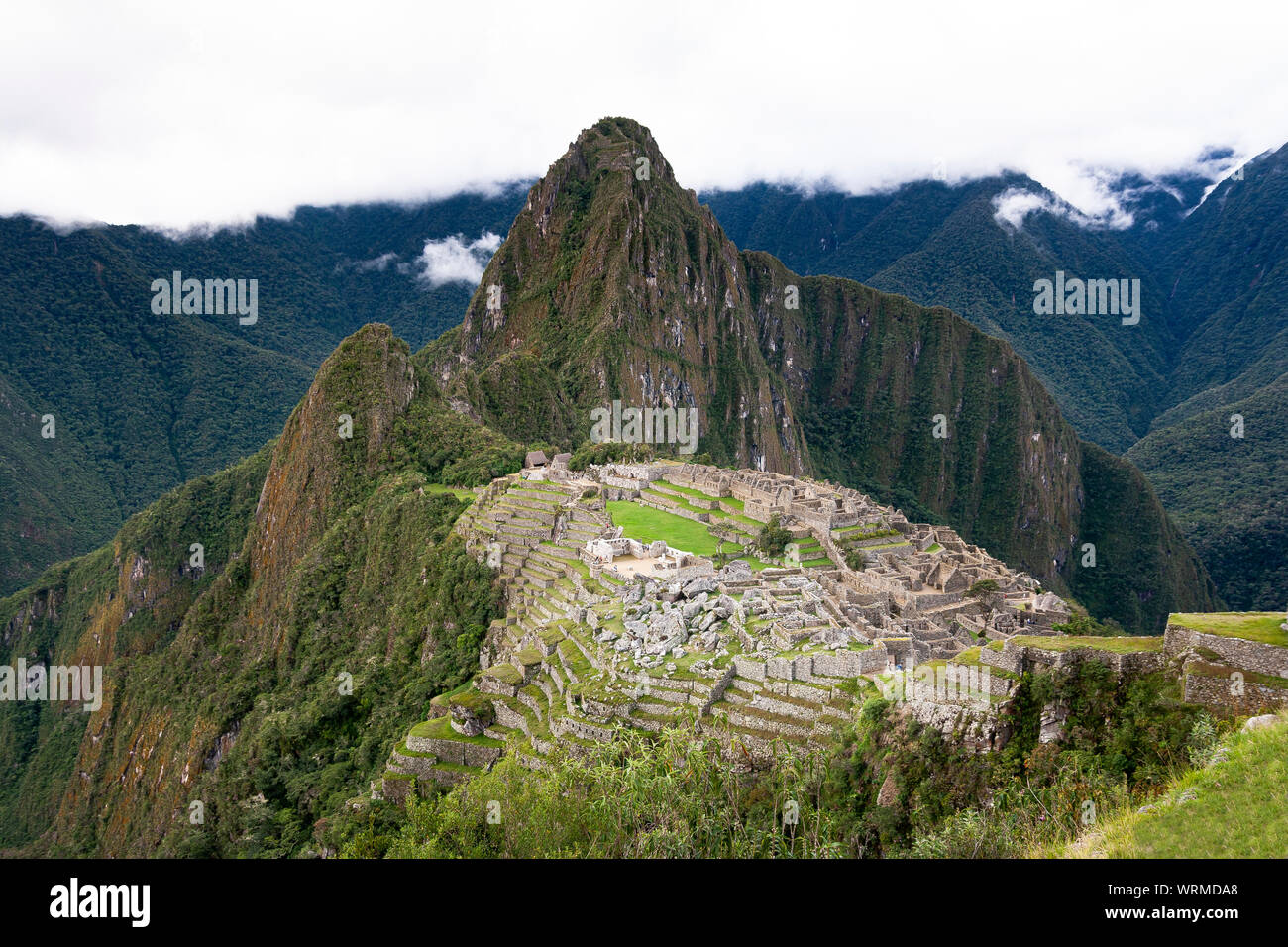 Machu Picchu rovine con cielo nuvoloso sul retro Foto Stock