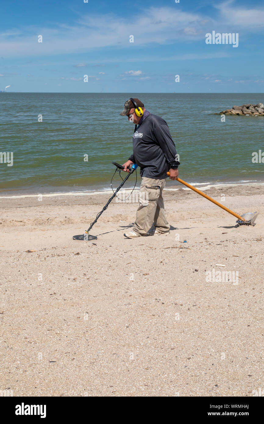 Oregon, Ohio - un uomo utilizza un rivelatore di metalli per la ricerca di monete e di altri metalli sulla spiaggia di Baia di Maumee parco dello stato. Foto Stock