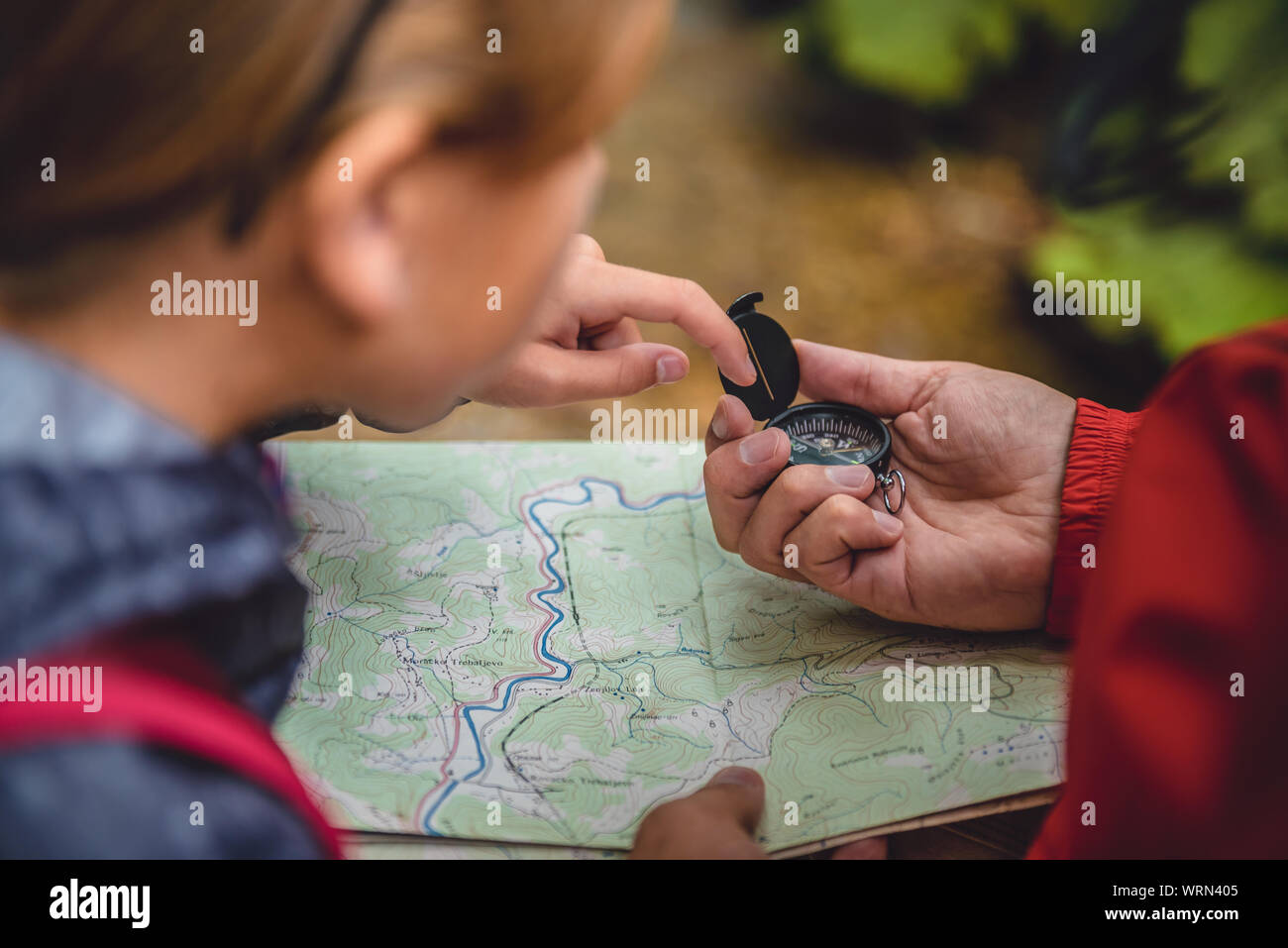 Padre e figlia escursioni nella foresta e la bussola di contenimento sulla mappa Foto Stock Padre e figlia escursioni nella foresta e la bussola di contenimento sulla mappa Foto Stock