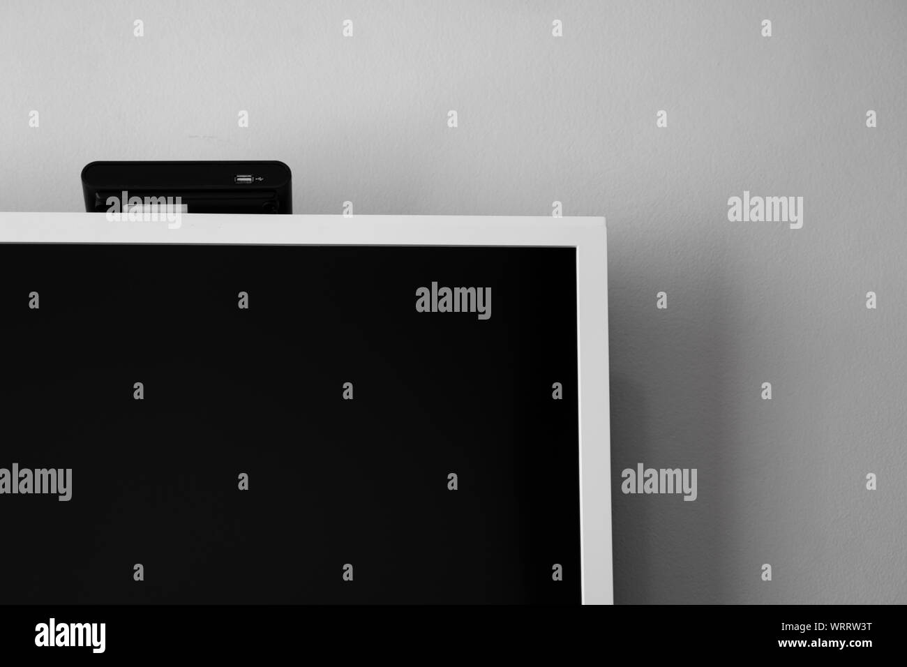 A LED o LCD schermo tv appesi al muro con un sintonizzatore TV in camera per la decorazione di interni design. Casa confortevole. Foto Stock