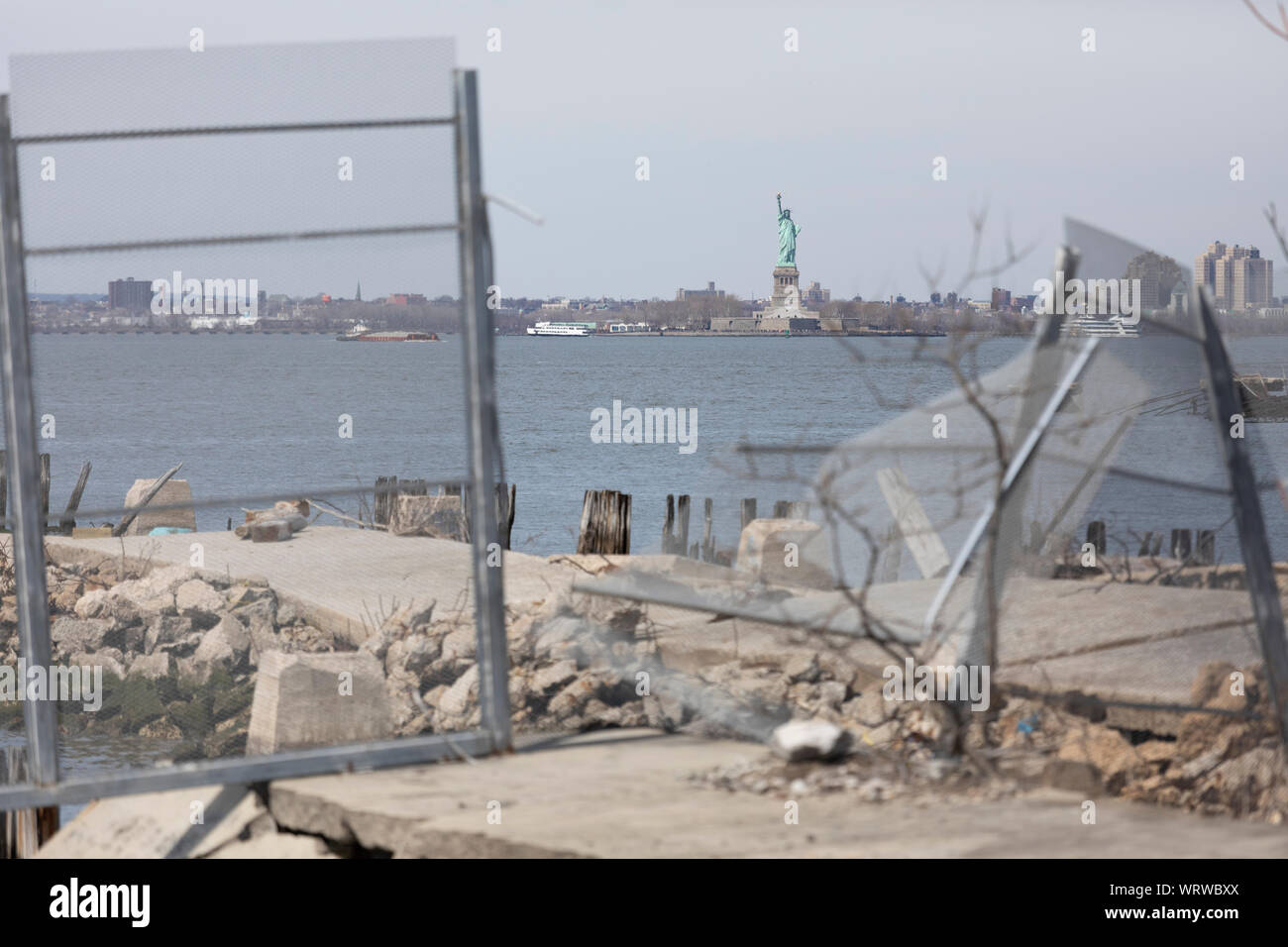 Statua della libertà vista da Brooklyn, New York. Porti interrotti e abbandonati di Bush Terminal in primo piano. Foto Stock