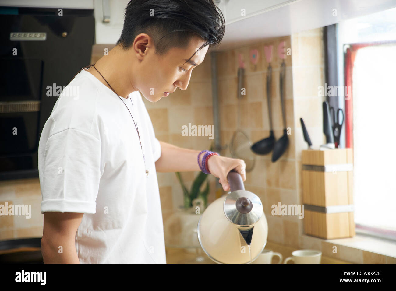 Giovane uomo asiatico facendo una tazza di caffè di gocciolamento Foto Stock