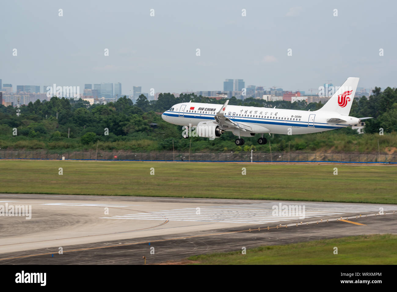 Aeroporto di Chengdu, nella provincia di Sichuan, Cina - 28 Agosto 2019 : Air China Airbus A320 Neo aereo commerciale lo sbarco a Chengdu con la città sullo sfondo. Foto Stock