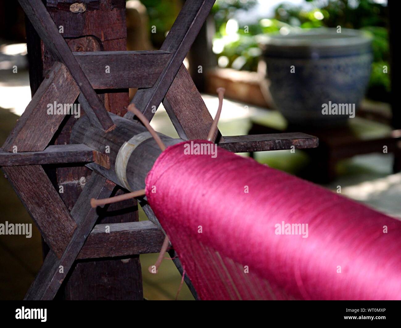 Close-up di seta rosa sulla ruota di filatura Foto Stock