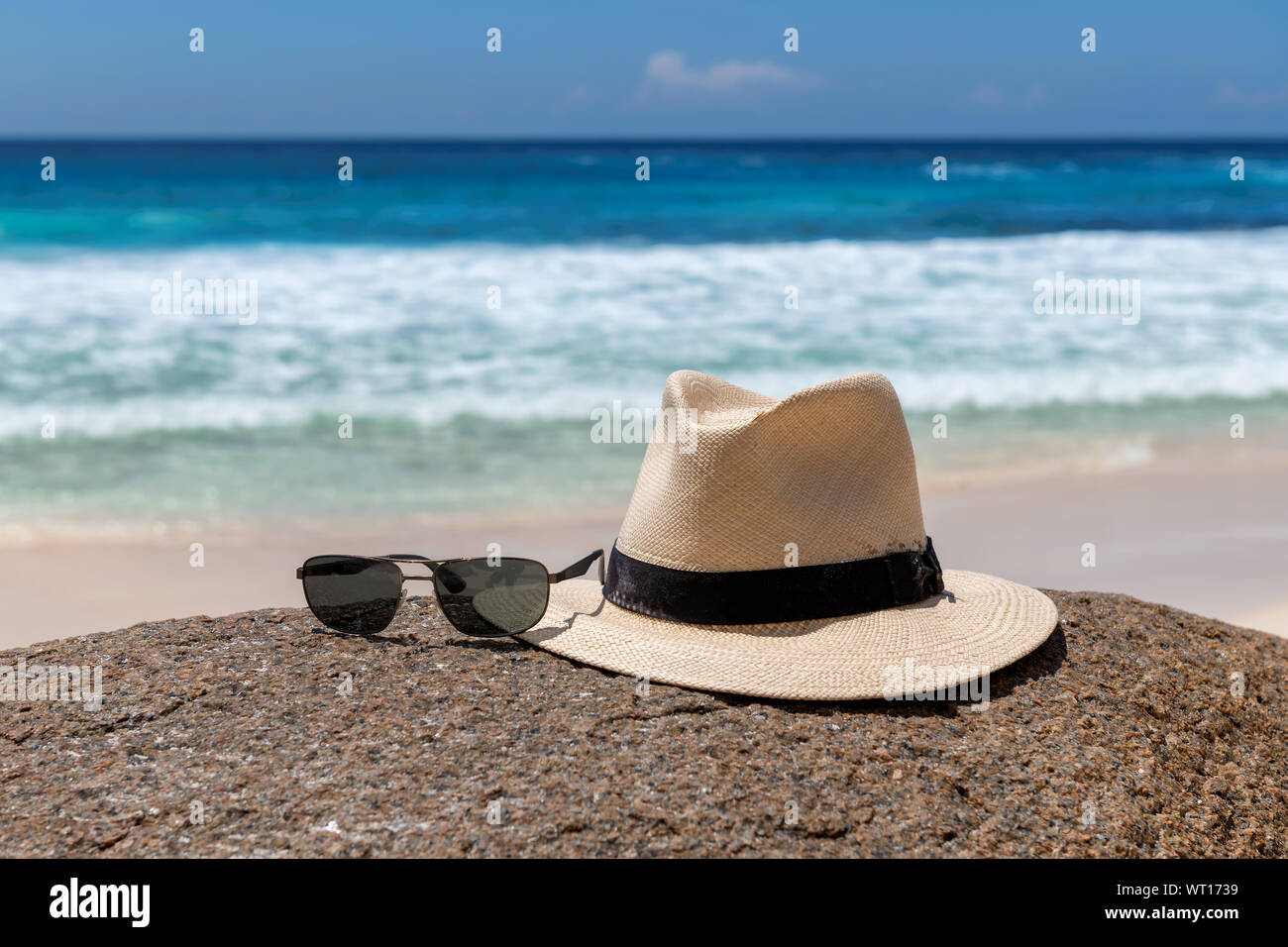 Cappello e occhiali da sole sulla spiaggia Foto Stock