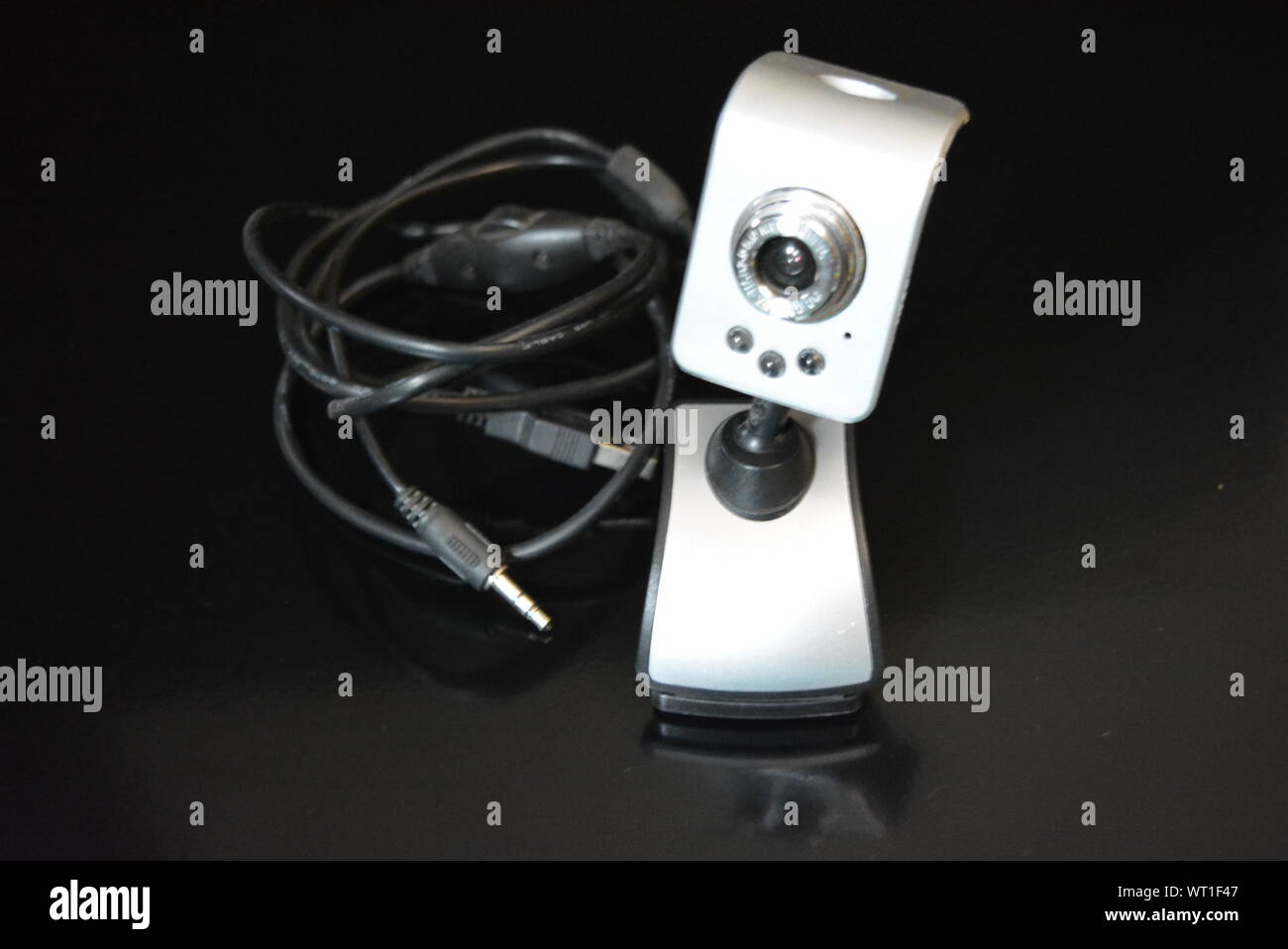 Una webcam color argento per il computer con clip per il monitor si trova su una superficie nera opaca con riflesso. Foto Stock