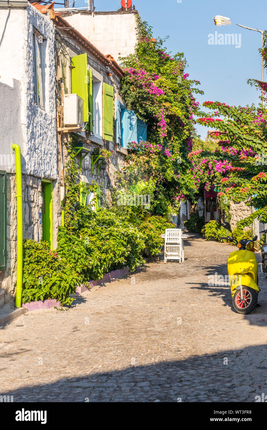 Casa con bougainvillaea ed il giallo scooter, Alacati, Izmir, Turchia Foto Stock