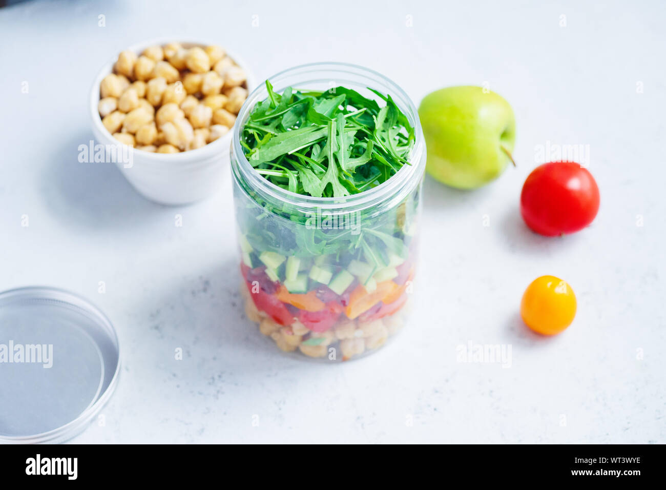 Una sana insalata con ceci e rucola in un vaso. Togliere facilmente il concetto di pranzo Foto Stock