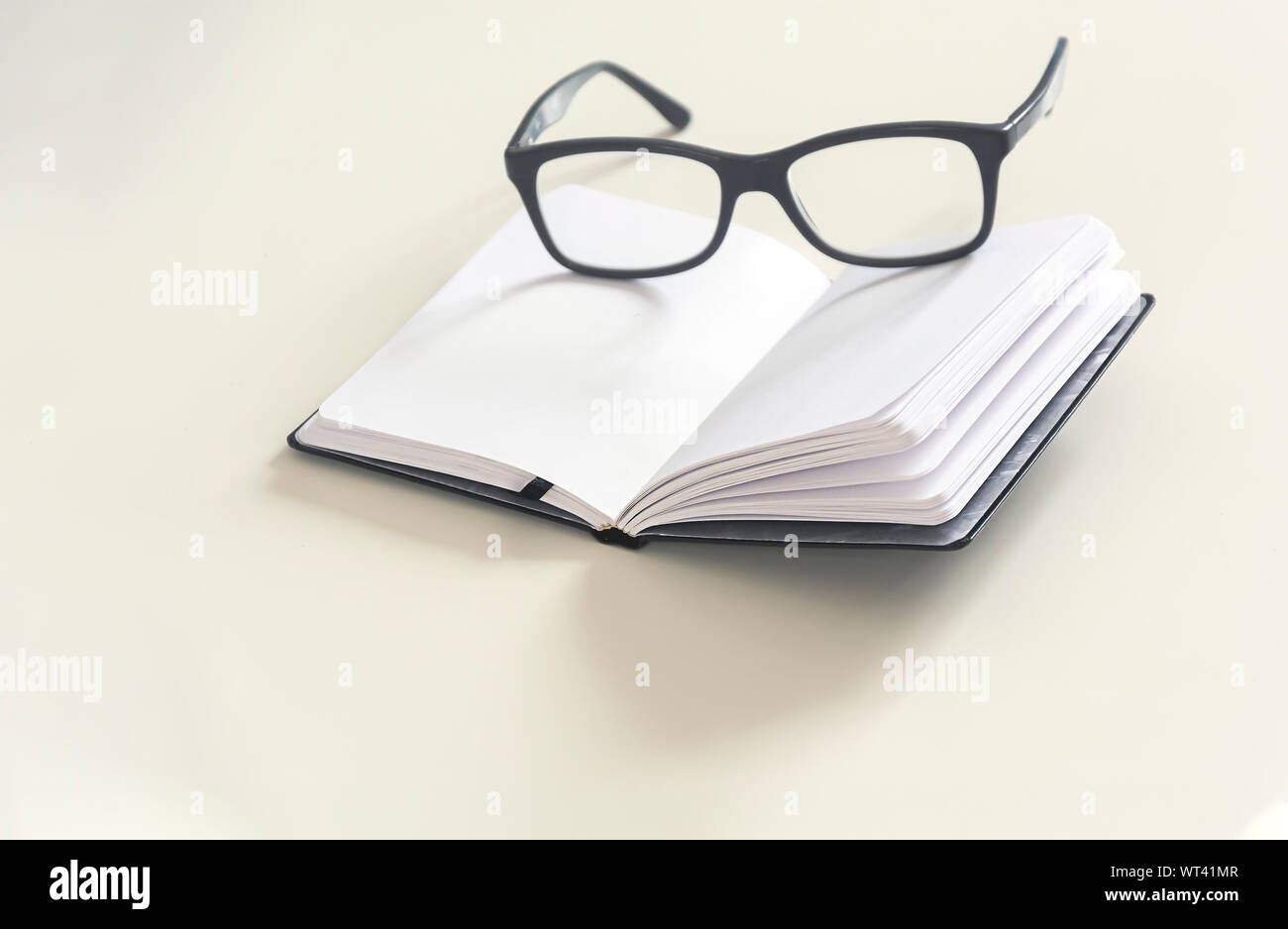 Un paio di occhiali su un quaderno con pagine vuote. Ufficio e studio. Pagine che deve ancora essere scritto Foto Stock