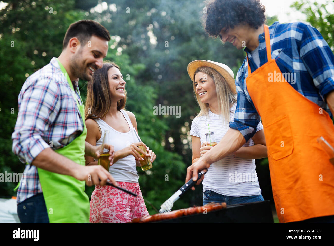 Gruppo di amici a un barbecue e grill party in natura Foto Stock