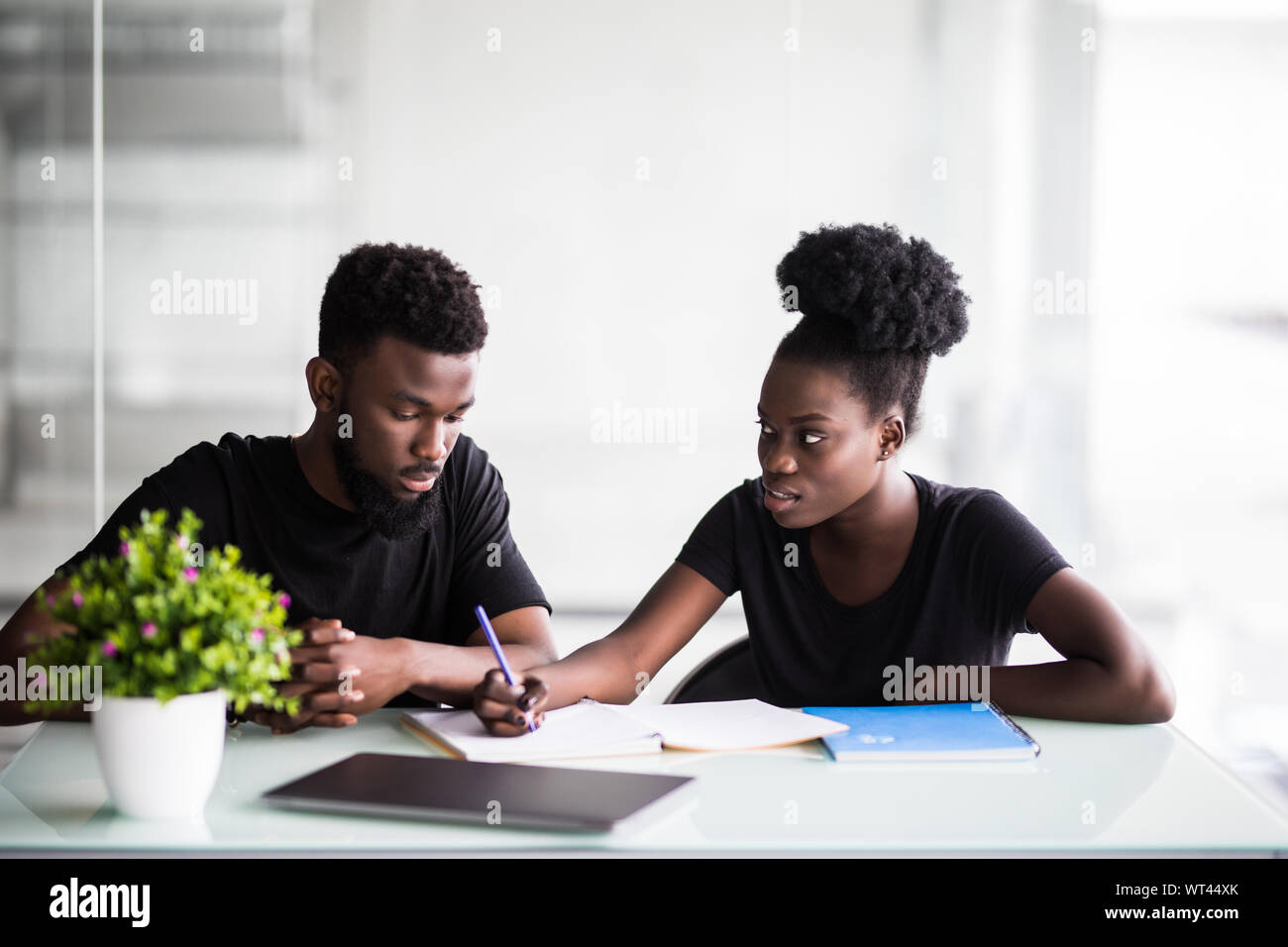 Immagine di due giovani imprenditori che interagiscono su riunione in ufficio Foto Stock