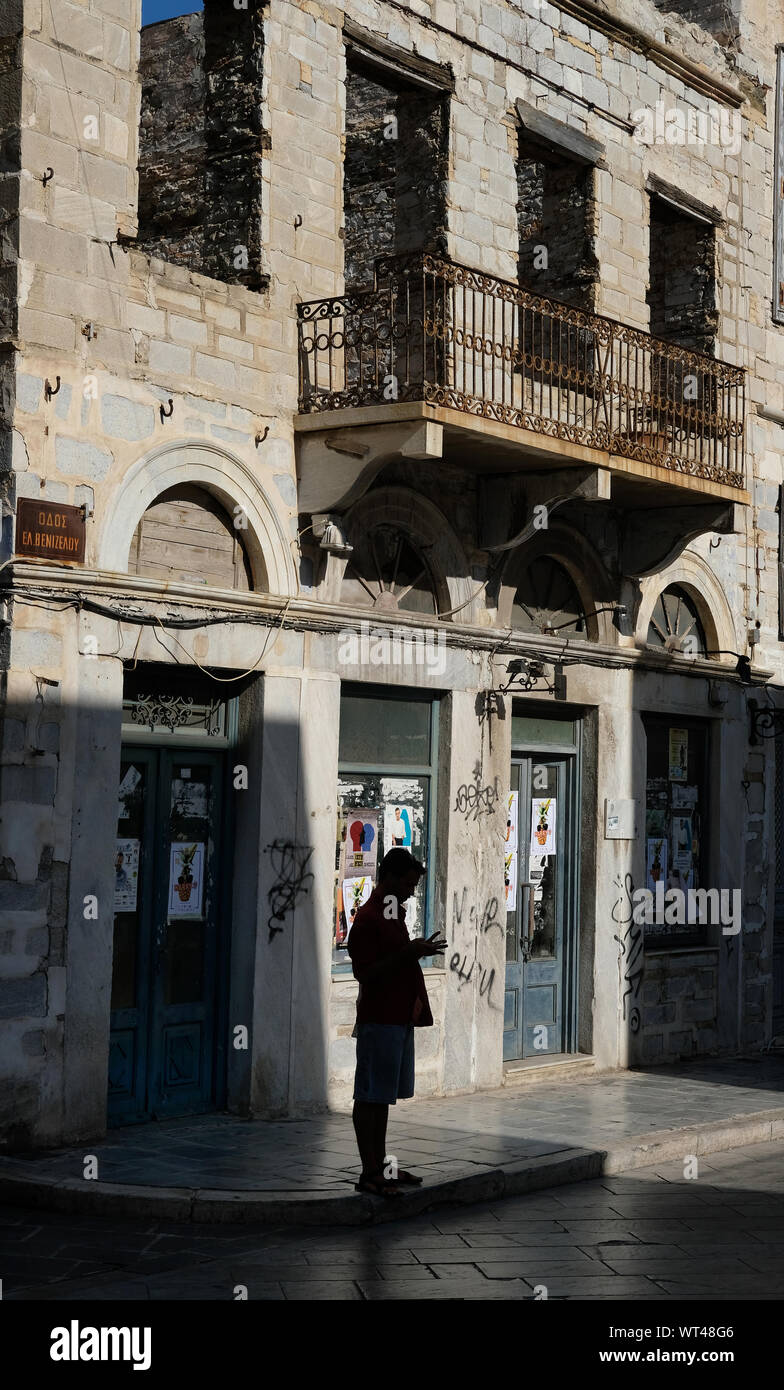 Figura di fronte a un edificio sfrontato di Syros, Grecia. Foto Stock