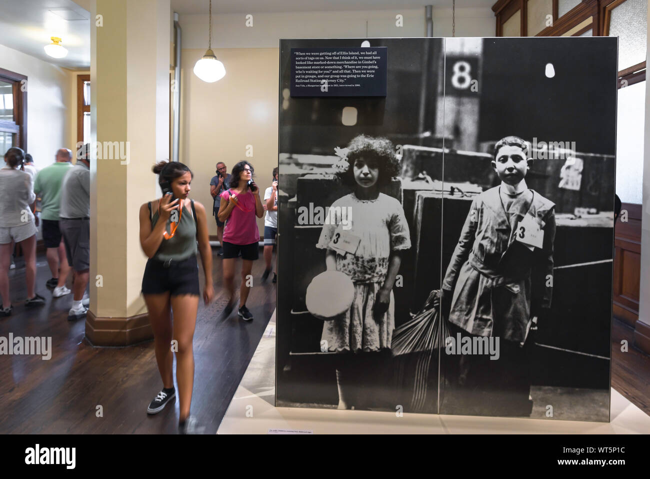 Ellis Island New York, vista di un visitatore all'interno del National Museum of Immigration passando una grande foto dei bambini immigrati degli inizi del XX secolo, USA Foto Stock
