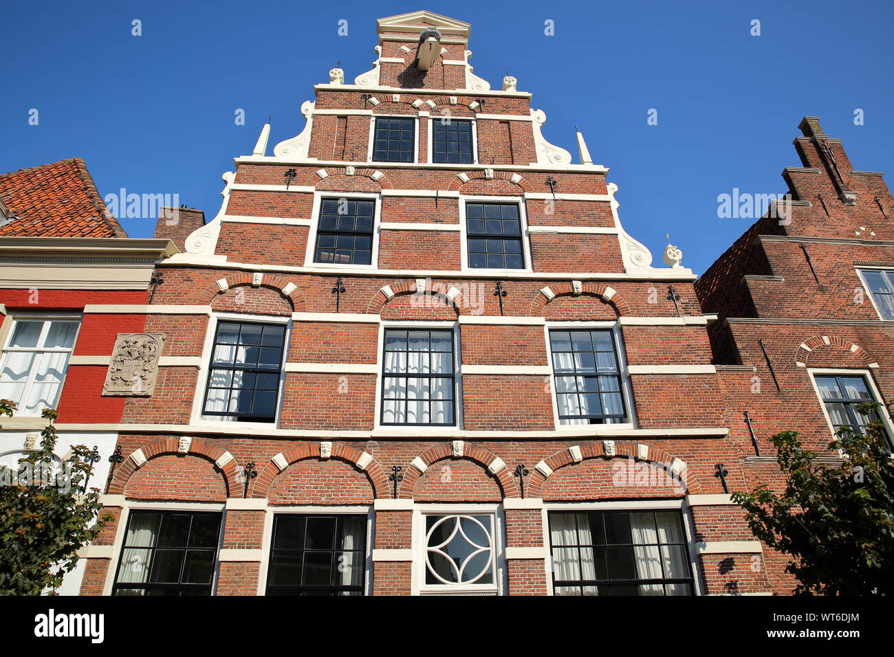 La facciata esterna di case storiche con intagli, situato sulla strada Cattenhage dentro la città fortificata di Naarden, Paesi Bassi Foto Stock