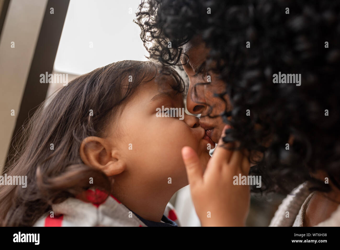 Adorabile bambina dando a sua madre un bacio Foto Stock