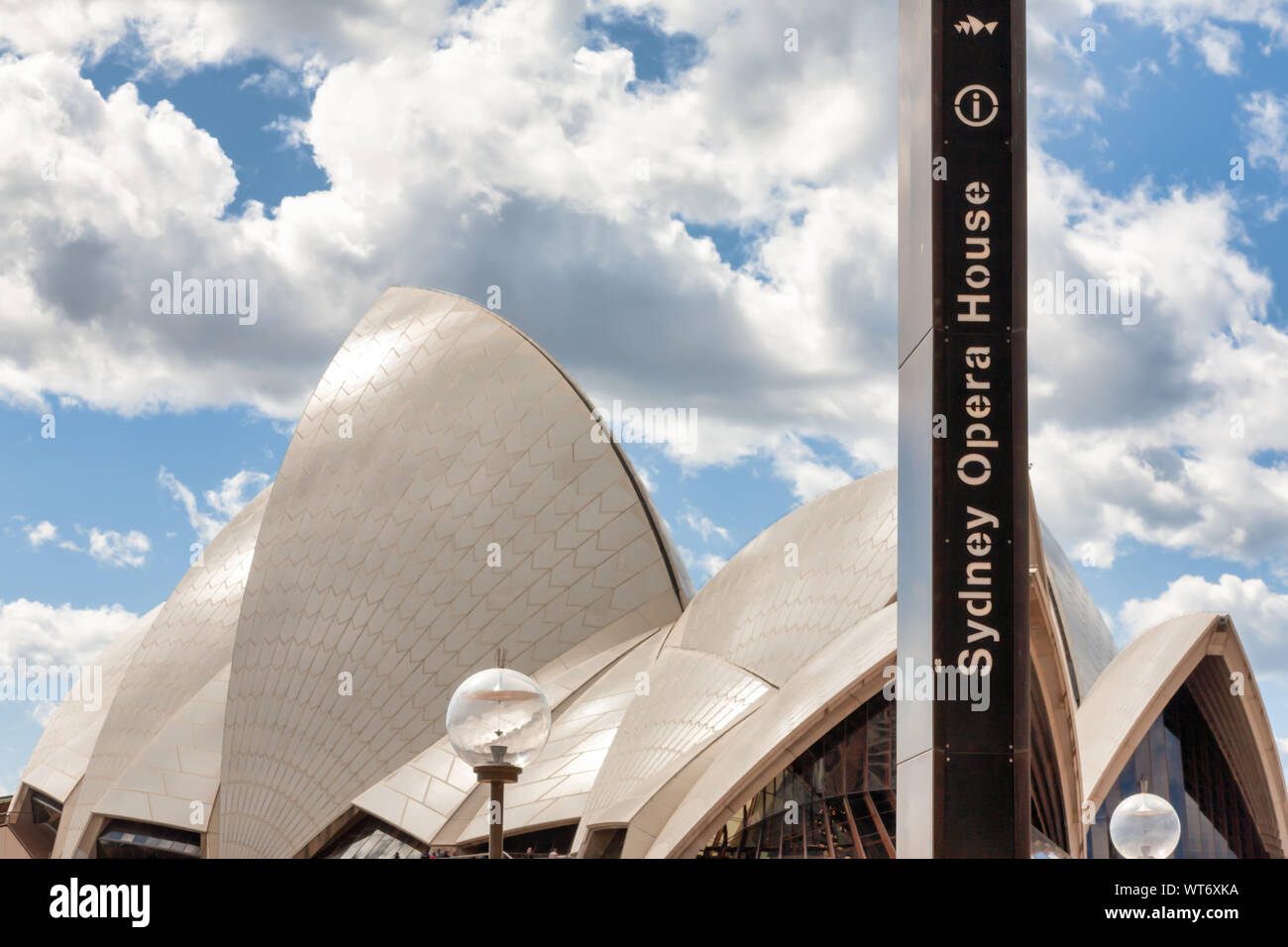 La Sydney Opera House e vele durante il giorno con il digital signage e cielo blu con nuvole bianche. Foto Stock