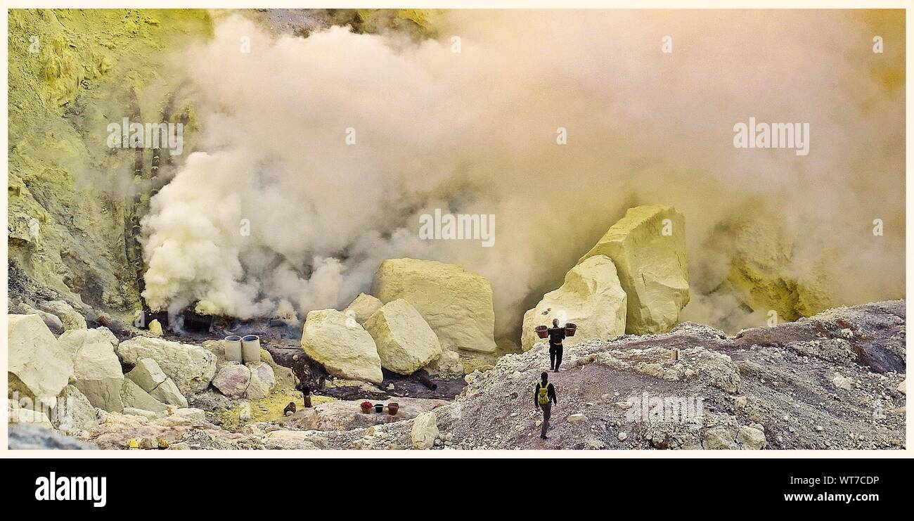 Estratto di minatori di zolfo puro dal cratere vulcanico Foto Stock