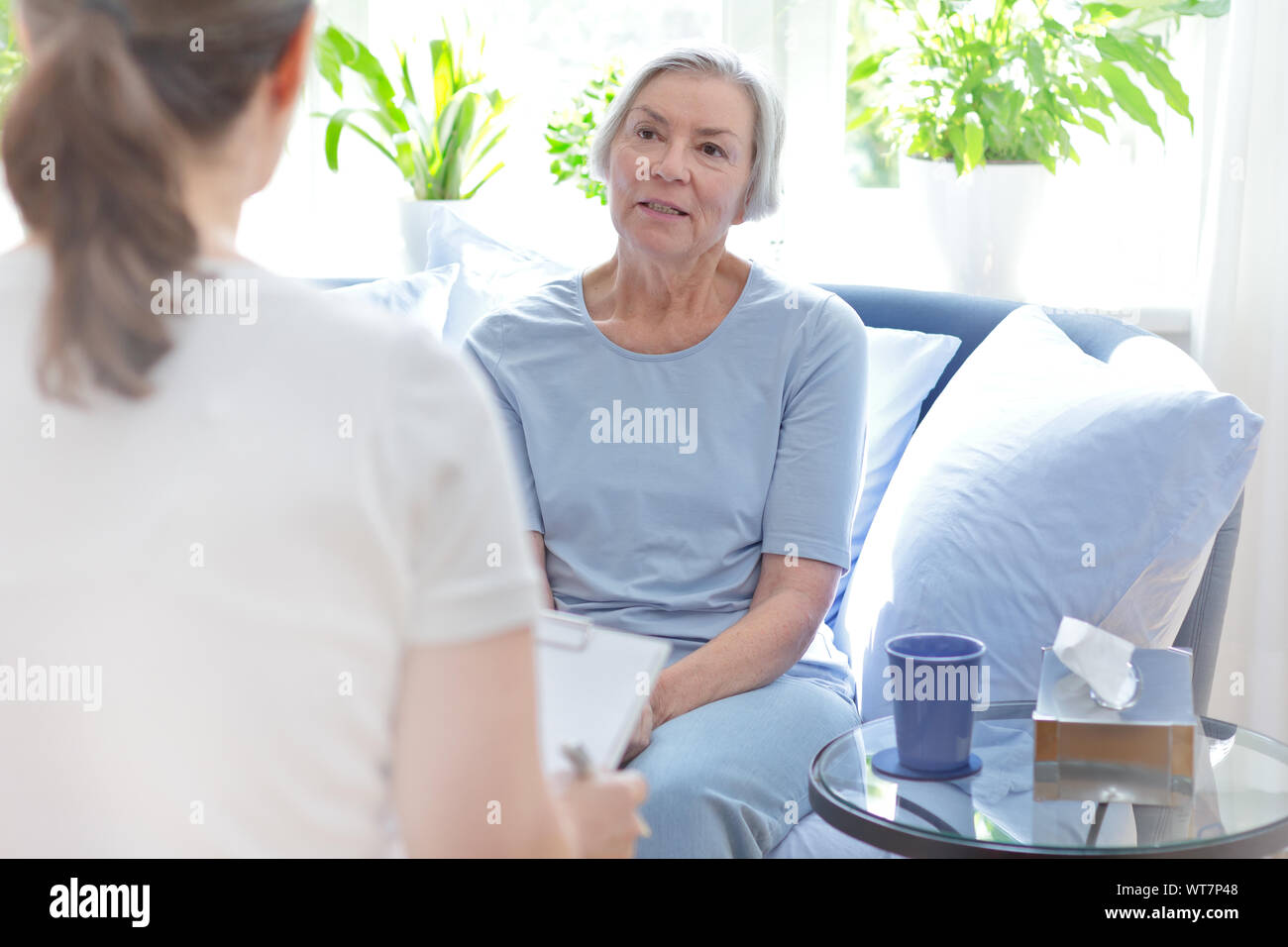 Parla il concetto di terapia: femmina medico a parlare con il suo anziano paziente circa i suoi problemi durante una sessione di consulenza. Foto Stock