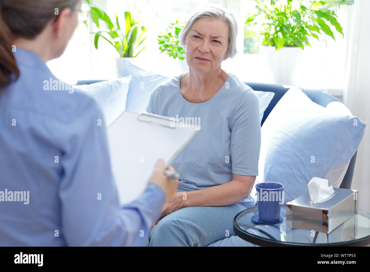 Concetto di consulenza: psicoterapeuta prendere appunti durante una sessione di terapia con lei sconvolto paziente femmina. Foto Stock