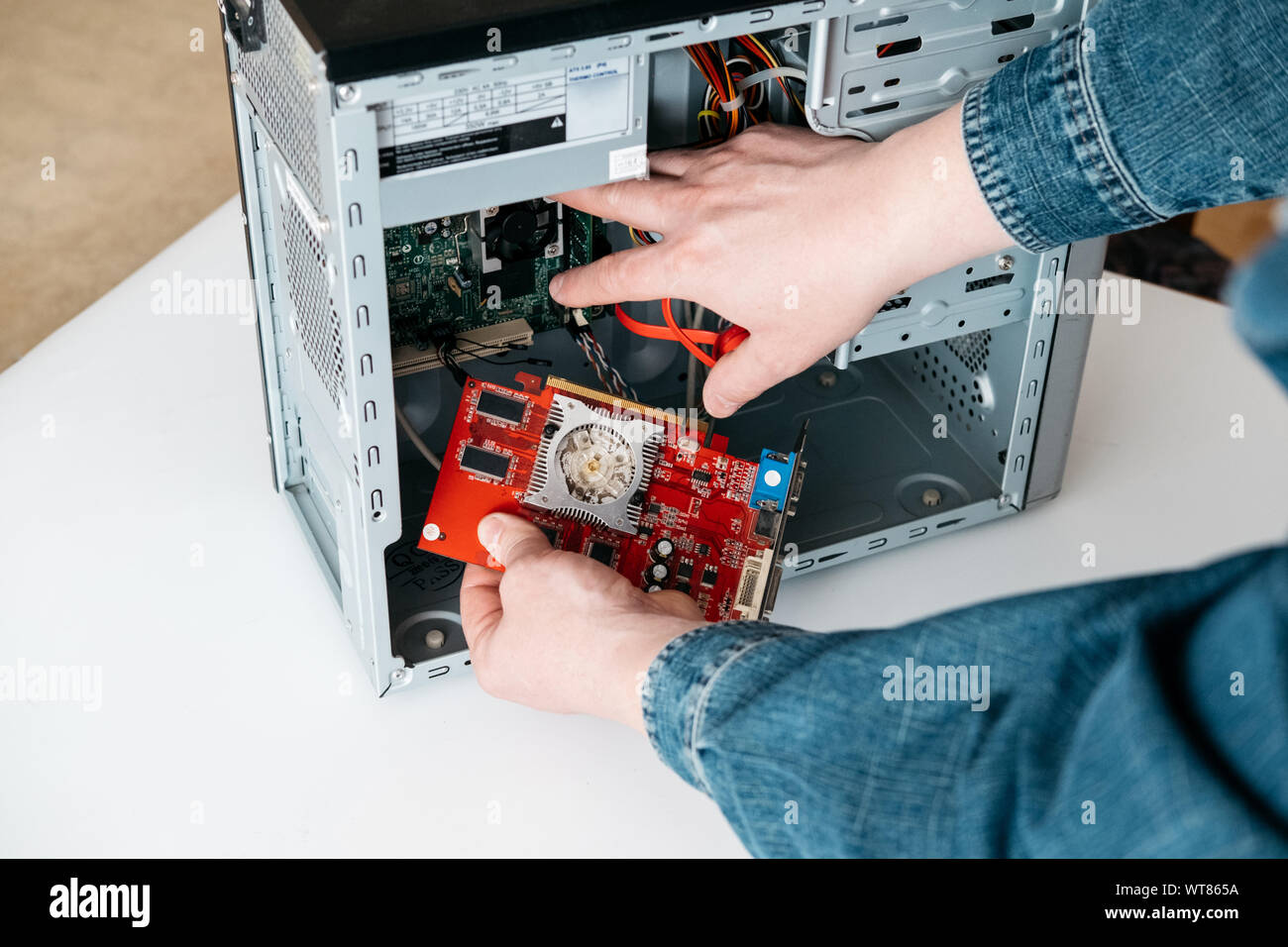 Repairman è togliere l'elaborazione grafica unità da personal computer. Ingegnere è diagnostica e fissaggio pc rotti in officina. Riparazione elettronica shop, Foto Stock