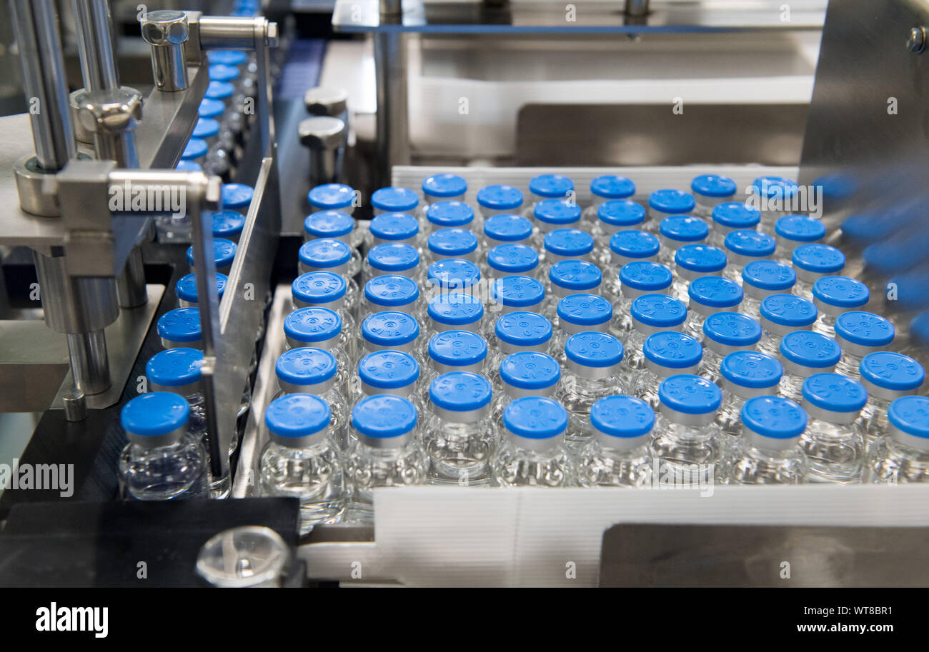 11 settembre 2019, Sassonia-Anhalt, Dessau-Roßlau: bottiglie piccole con una sterile il cancro farmaco esecuzione in Oncotec Pharma produzione attraverso un nuovo impianto. Il produttore di elementi essenziali di cancro e malattie autoimmuni farmaci attualmente impiega circa 300 persone all'Dessau-Roßlau BioPharmaPark ed ora ha investito 35 milioni di euro in nuovi impianti. Foto: Hendrik Schmidt/dpa-Zentralbild/ZB Foto Stock