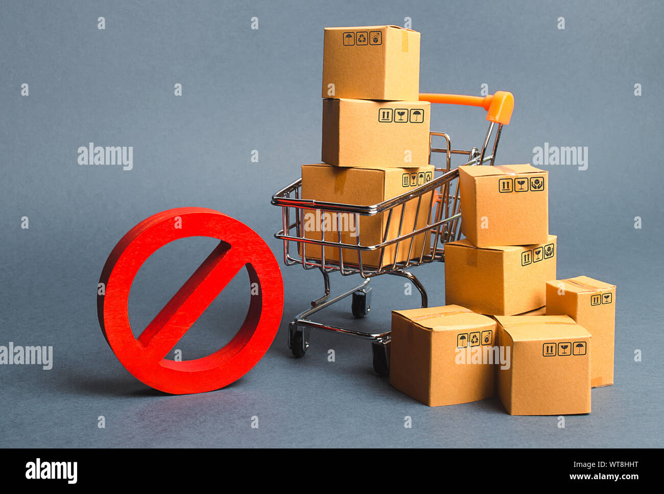 Scatole di cartone, carrello per supermercati e il simbolo rosso NO. Embargo, guerre commerciali. Restrizione all' importazione di merci, proprietarie per il business. Inabil Foto Stock