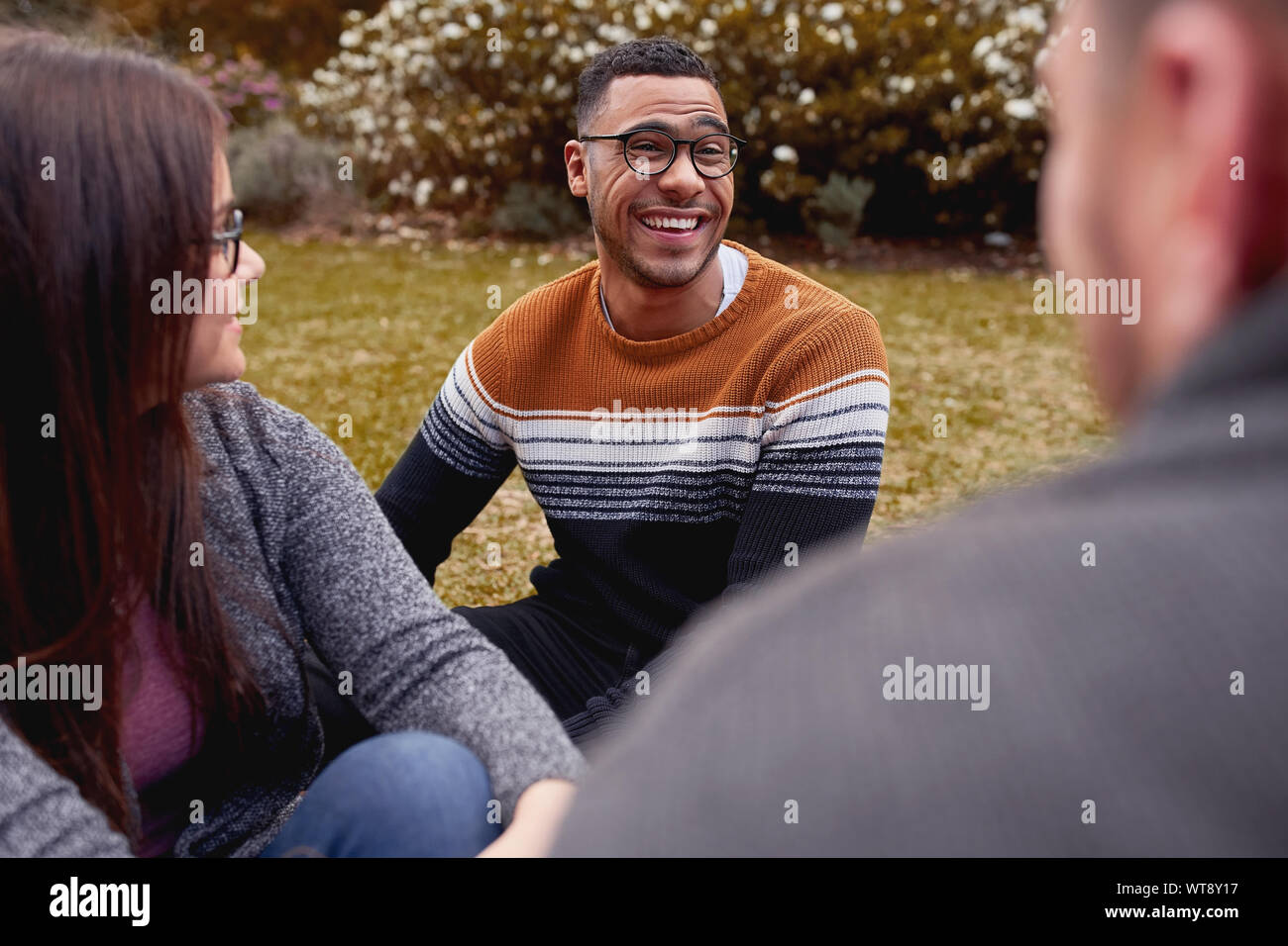 Ritratto di un giovane sorridente african american uomo seduto insieme con il suo amico godendo nel parco in Brasile Foto Stock