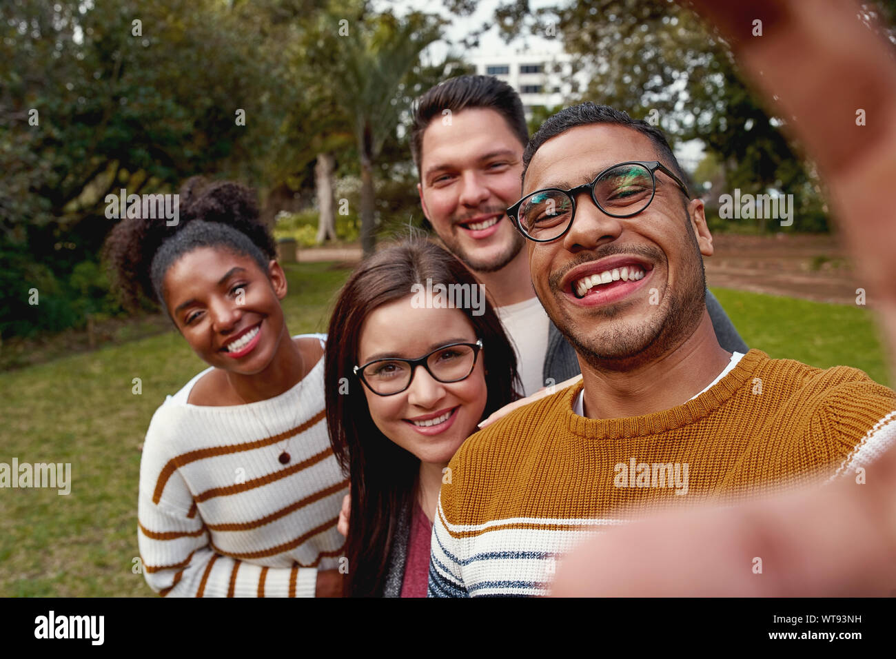 Multi etnico per coloro che godono di tempo insieme e tenendo selfie nel parco Foto Stock