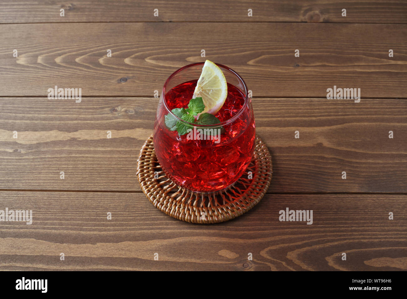 Bicchiere di tè freddo drink rosso closeup isolato sul tavolo Foto Stock