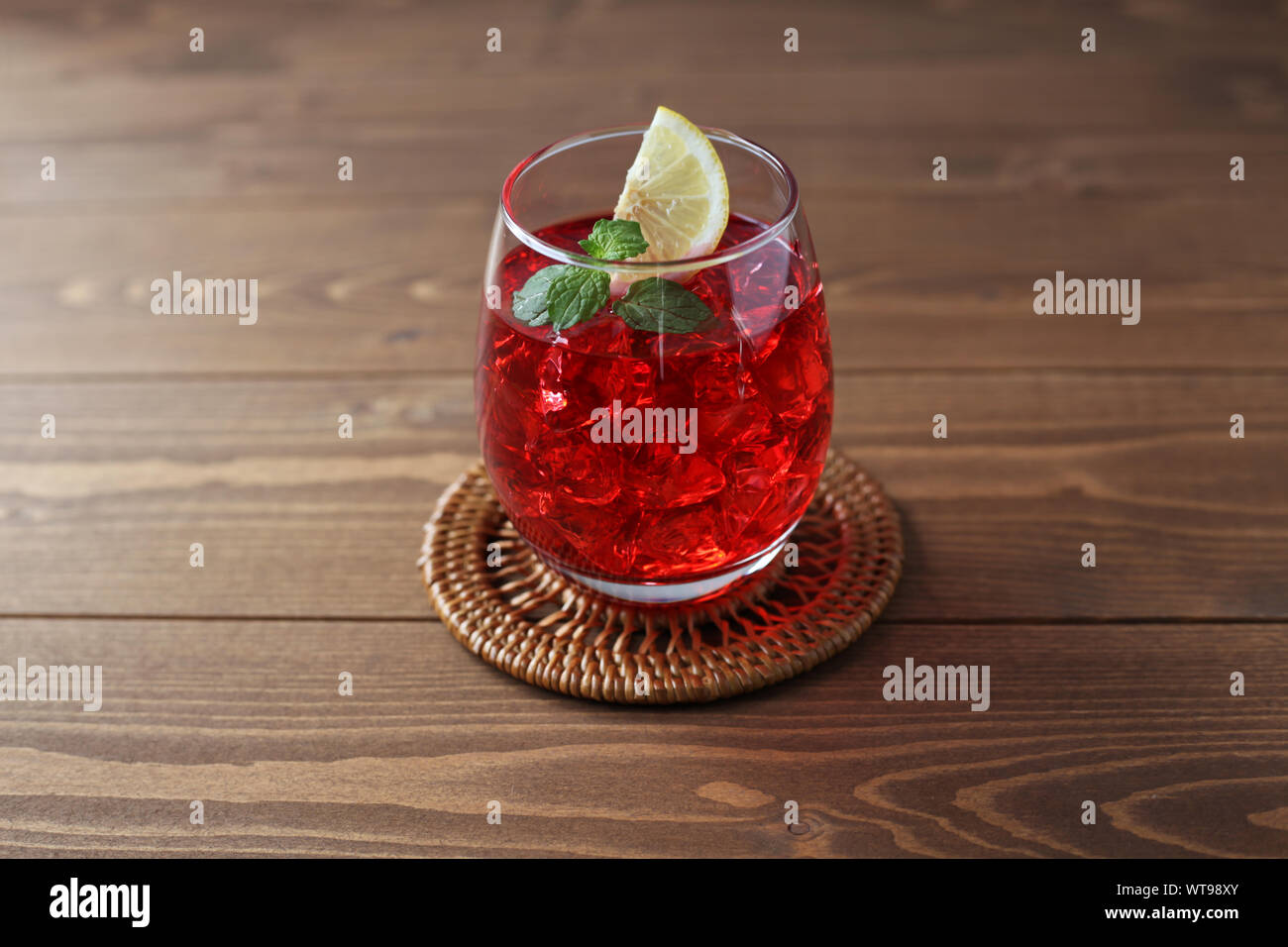 Bicchiere di tè freddo drink rosso closeup isolato sul tavolo Foto Stock
