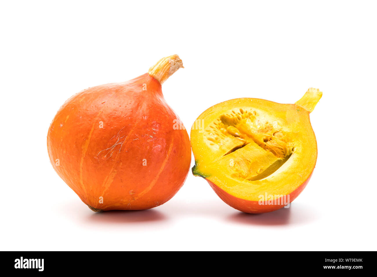 Intero e metà Red Kuri squash isolati su sfondo bianco Foto Stock