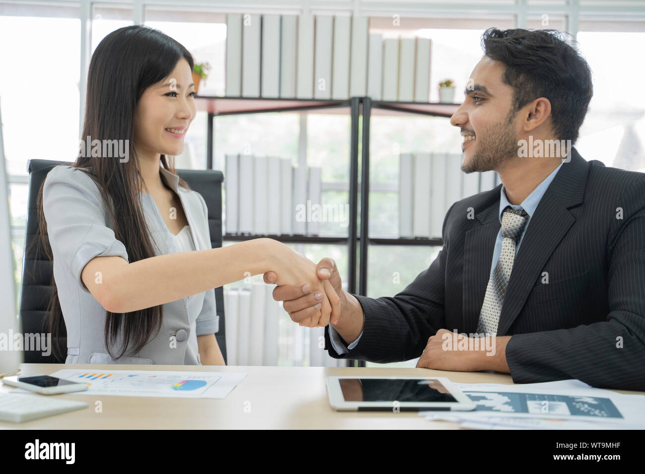 Gli uomini d' affari stringono le mani con asian business donna, dopo aver terminato una riunione. Foto Stock