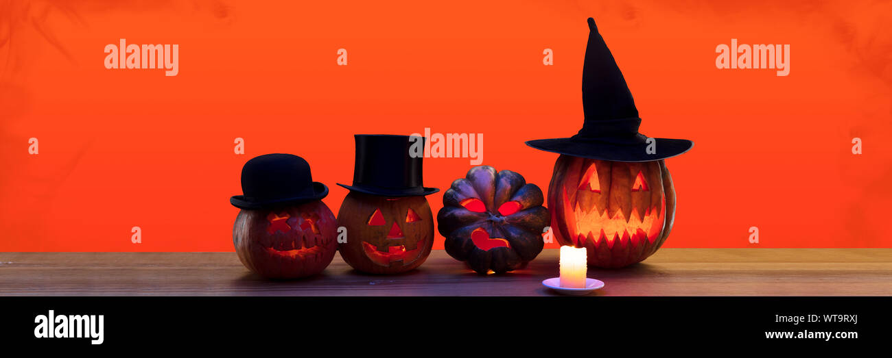 Scary zucche in cappelli su sfondo nero, la notte della paura. Fiamme di fuoco e le candele. Halloween venerdì nero, cyber lunedì, vendite, concetto d'autunno. Volantino per la vostra pubblicità. Foto Stock
