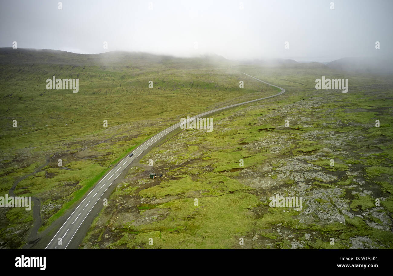 Drone vista di autostrada in tutta la pianura roccioso coperto con erba su nebbioso giorno Foto Stock