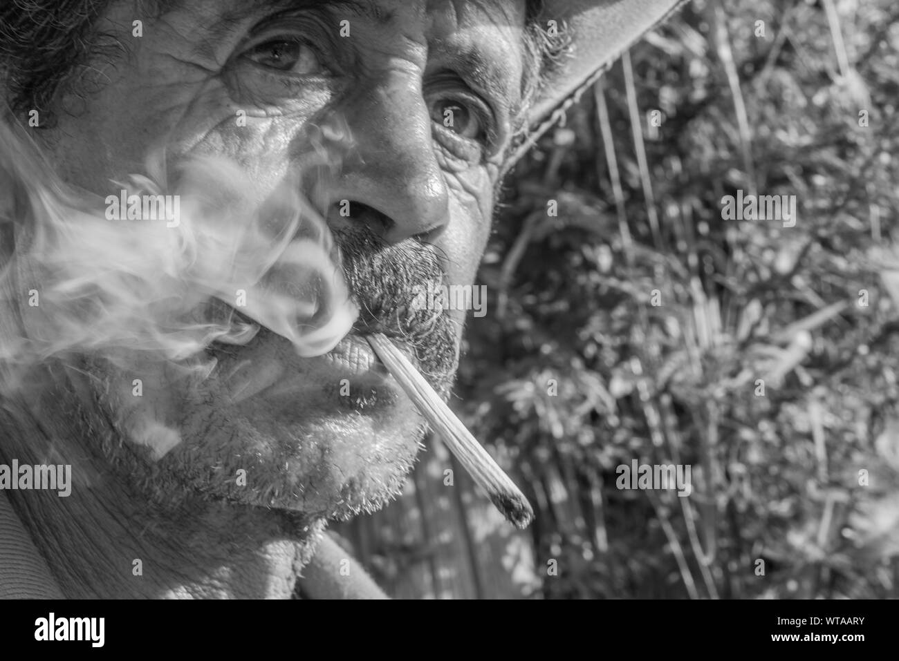 Uomo di campagna fuma sigarette fatte a mano Foto Stock