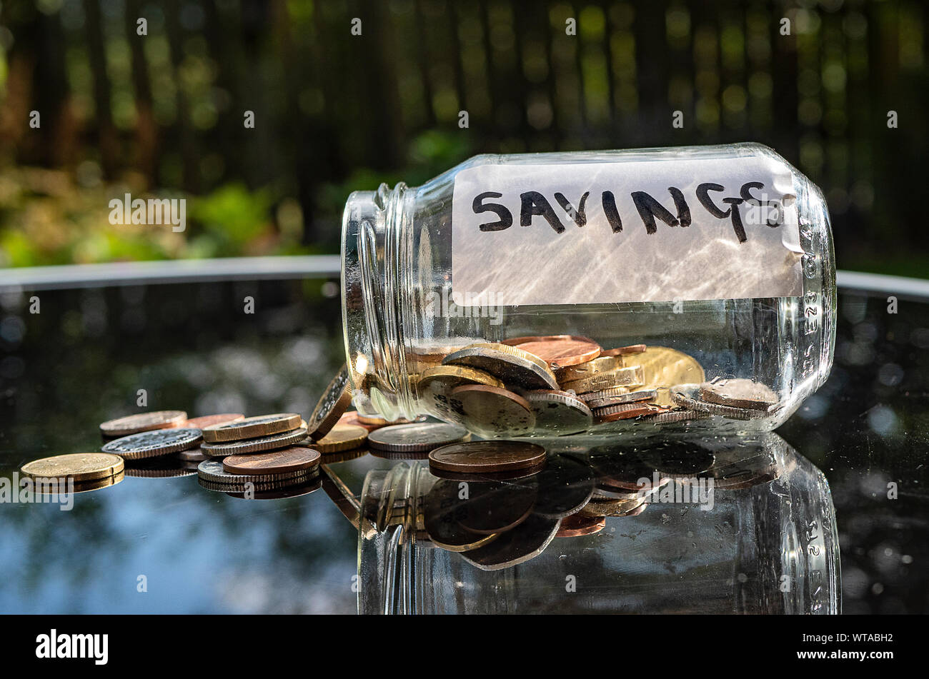 Vaso di denaro versato. Una etichetta dicendo di risparmio. Foto Stock