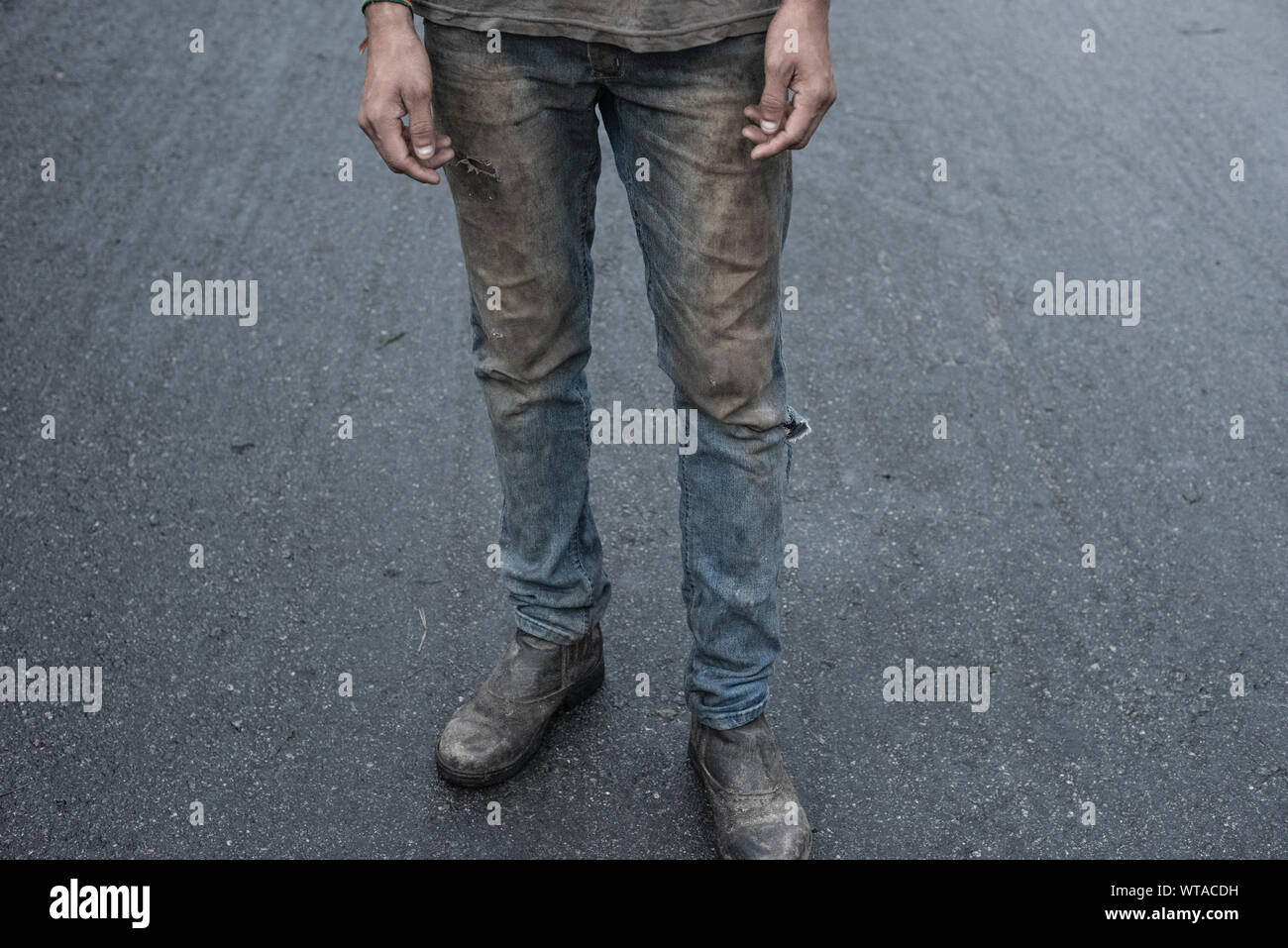 Uomo al lavoro con vestiti molto sporchi Foto Stock