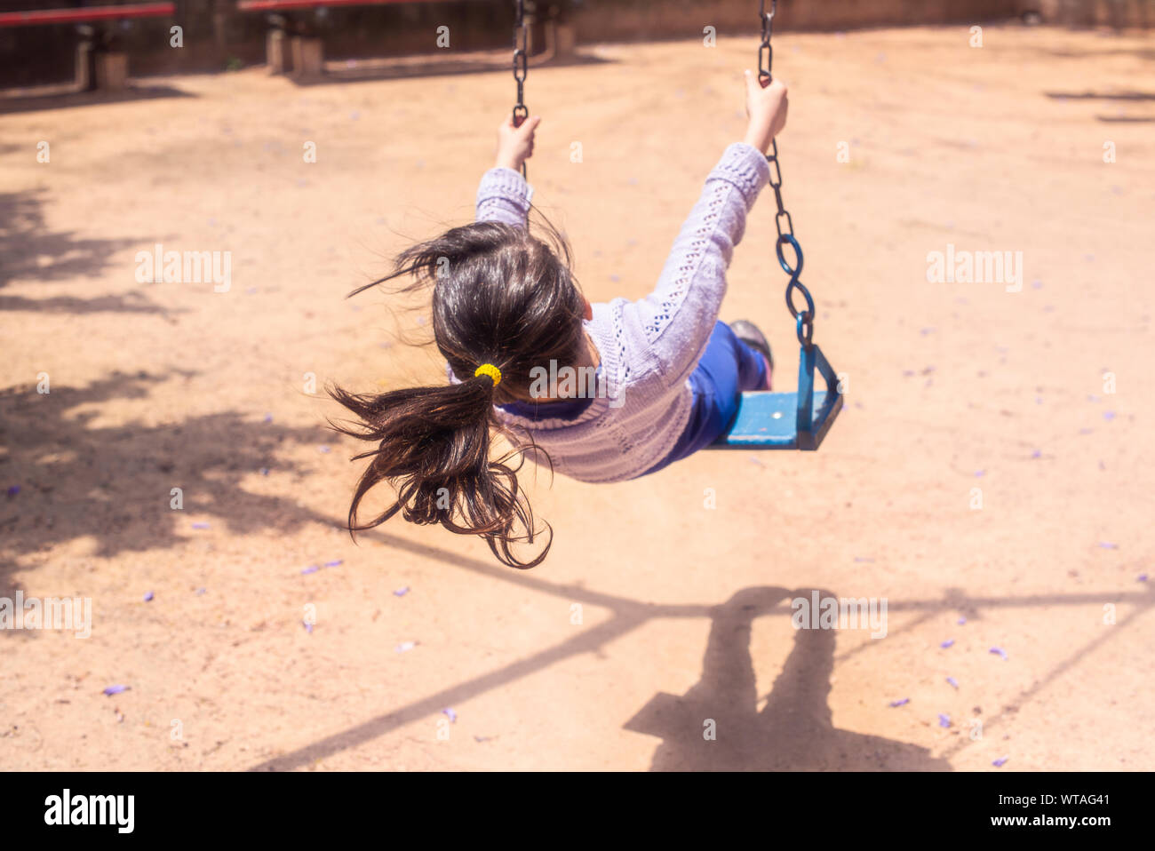 Bambina oscillanti in parco giochi Foto Stock