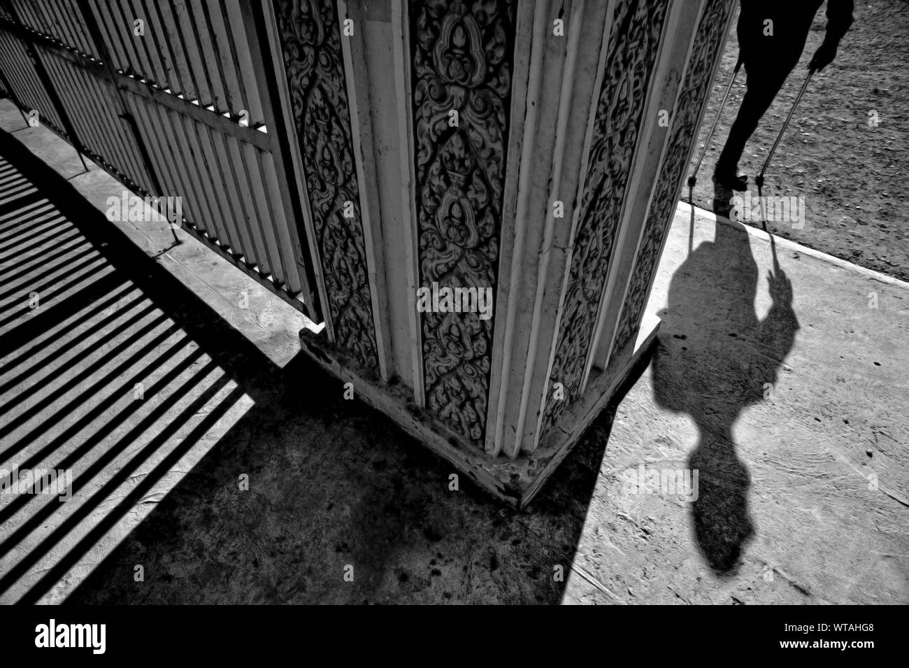 One-man zampe con stampella entrando nel museo del genocidio Museo di Tuol Sleng Foto Stock