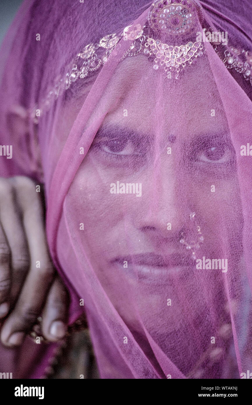 Donna di Rajasthani che ricopre la faccia con odhni e un borla sulla testa Foto Stock