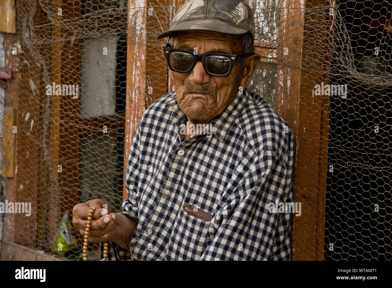 Blind vecchio uomo che prega per le strade tenendo un japamala Foto Stock