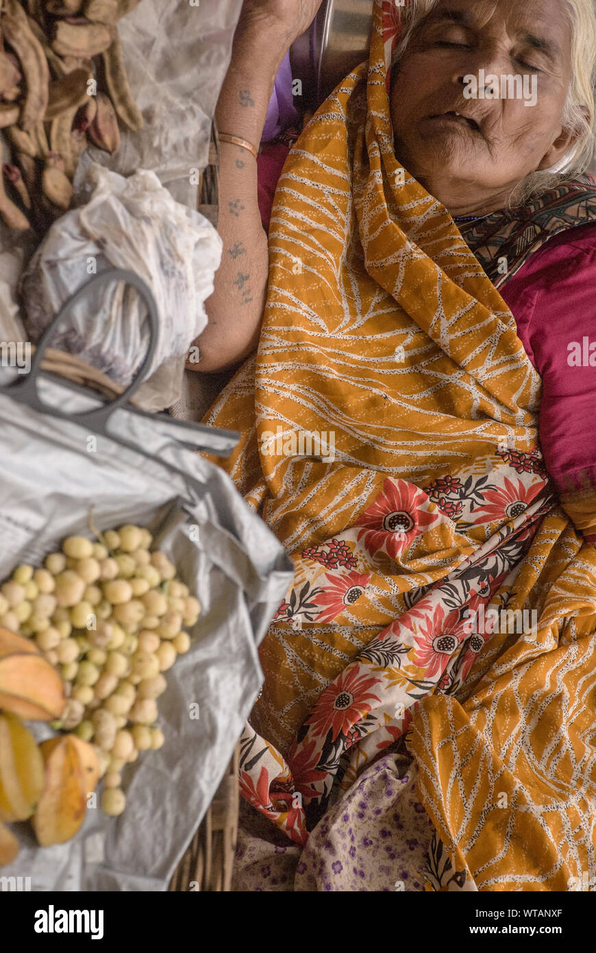 Fornitore di frutta tenendo un pisolino nelle strade Foto Stock