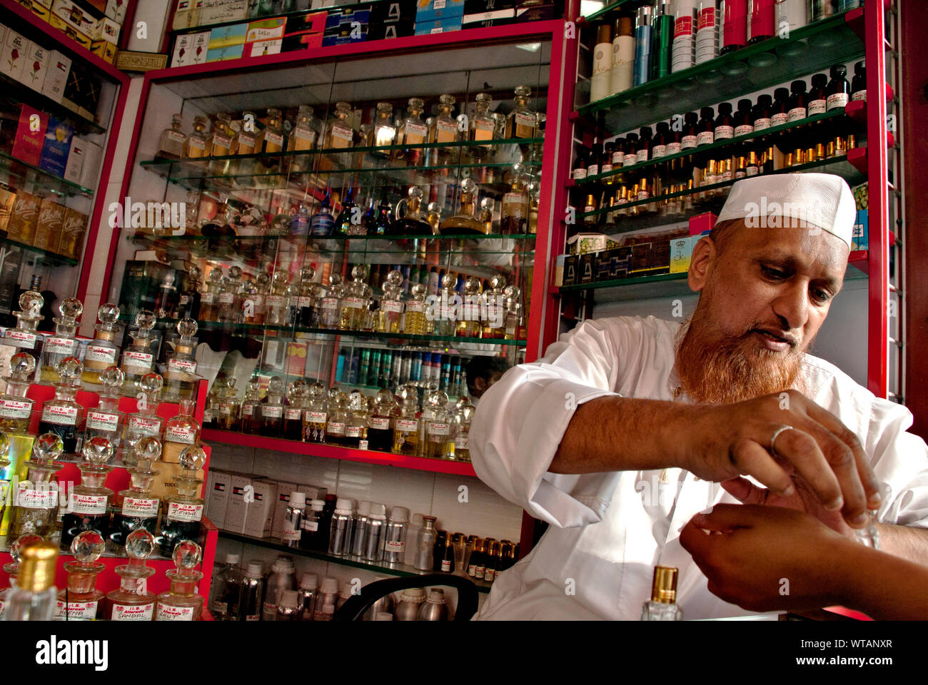 Un profumo ed essenza venditore musulmano assiste client Foto Stock